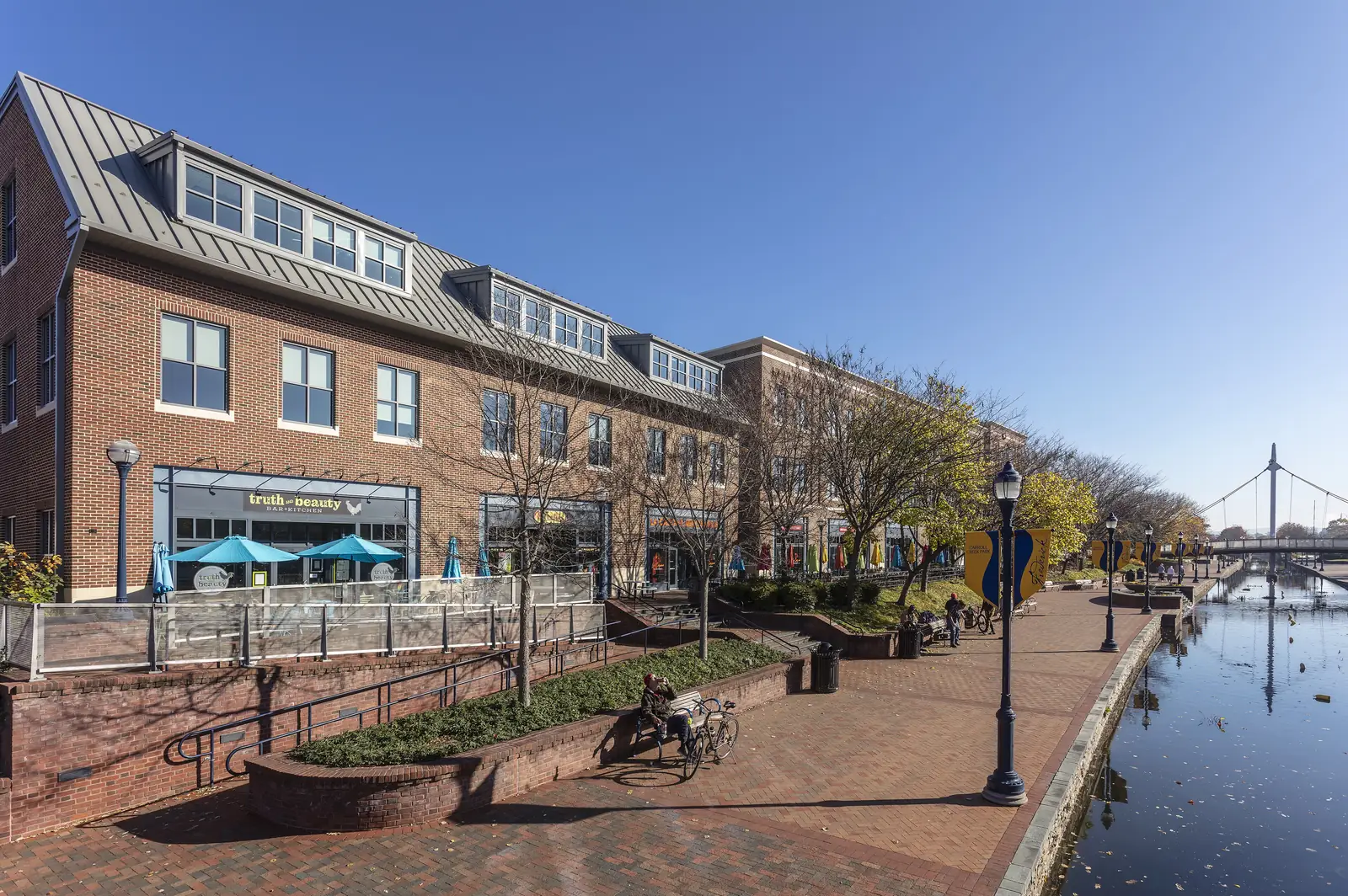 Carroll Creek Linear Park in downtown Frederick: the brick promenade, storefronts and footbridge over the creek